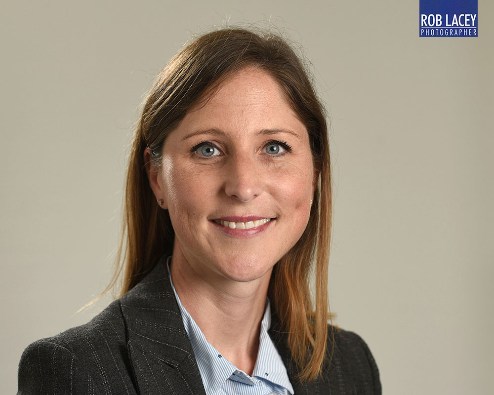 Headshot female grey background suit horizontal