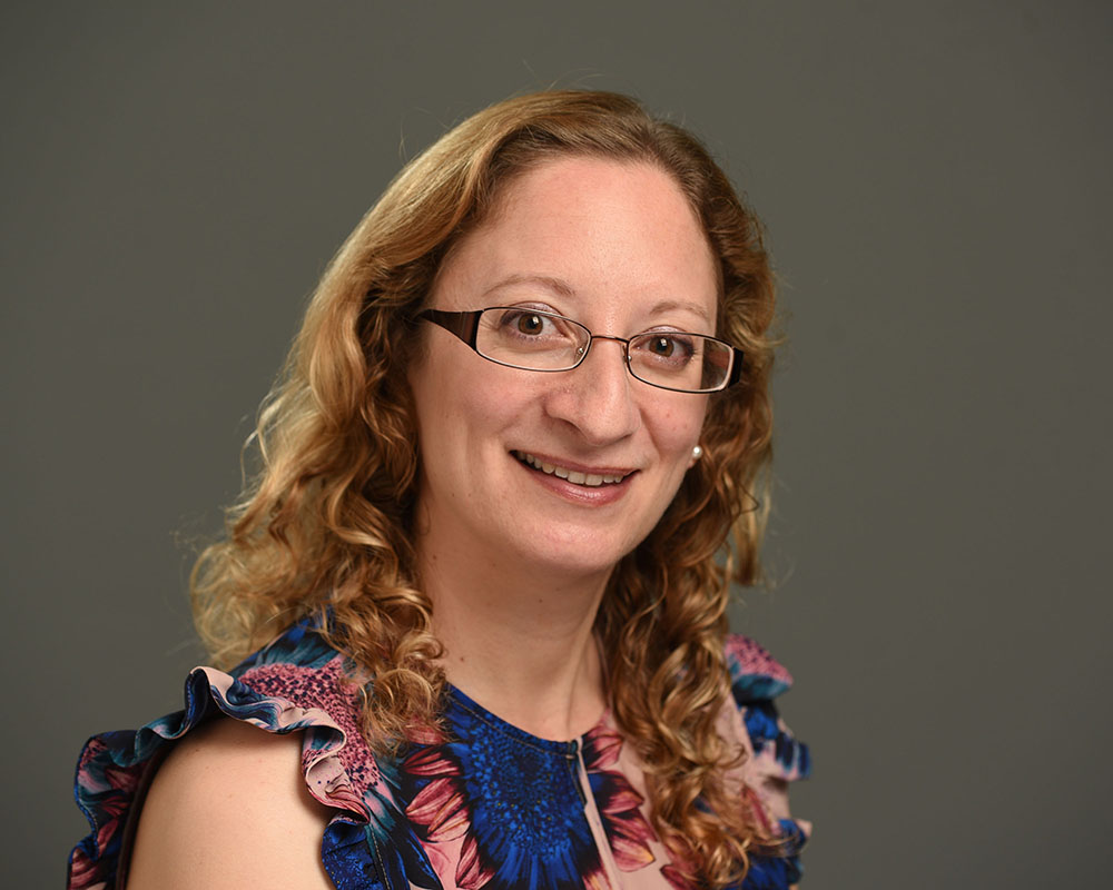 female business headshot on grey background