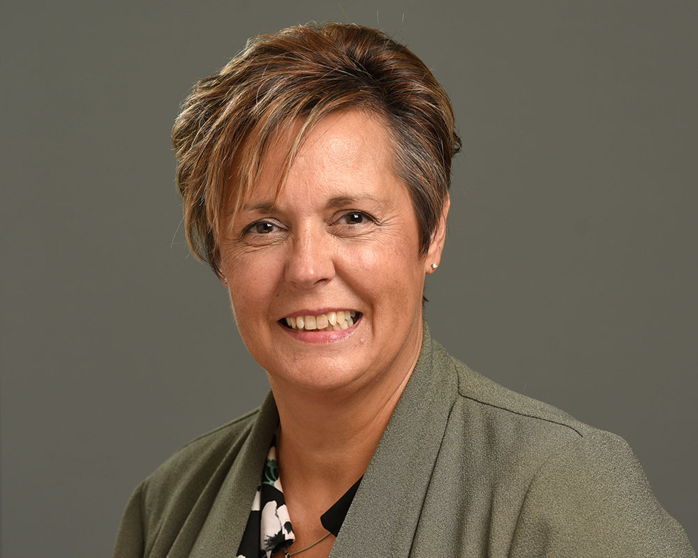Female corporate headshot on grey background
