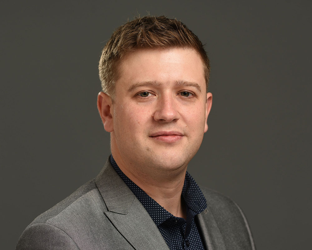 Male business headshot on grey background