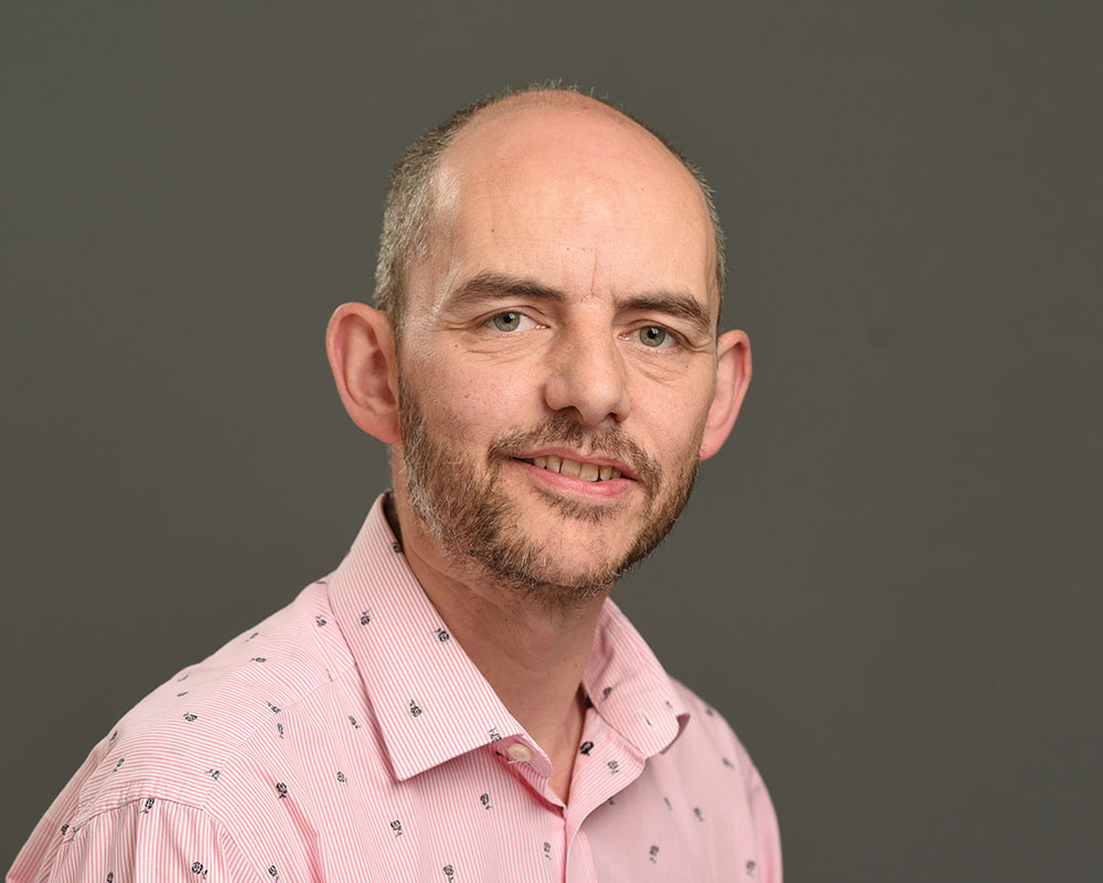 Male corporate headshot on grey background